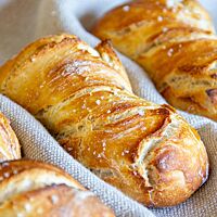 Drei goldgelbe Dinkelbrötchen mit rustikalem Ausbund sind mit weißem Fleur de Sel bestreut.