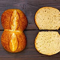 Die Weizenbrötchen aus dem ersten Backversuch haben eine elastische, kleinporige Krume und eine goldbraun ausgebackene Kruste mit kleinen Bläschen auf der Obefläche.