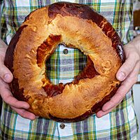 ausgebackene Pogne de Romans wird von zwei Händen gehalten.