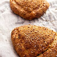 Zwei dreieckig geformte Weihnachtsbrote liegen auf einem Leinentuch.