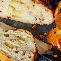 Die lockere, weiche Krume der herzhaften Brioche ist umgeben von der goldbraun ausgebackenen, glänzenden Kruste.