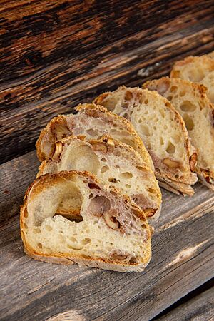 Im Anschnitt zeigt das Wurzelbrot die Walnüsse in der lockeren, elastischen Krume.