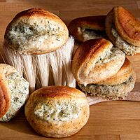 In der Kruste der ausgebackenen Teigmuscheln ist der Vollkornanteil zu sehen. Sie sind mit einer Mischung aus Ziegenkäse, Dill und Parmesan gefüllt.