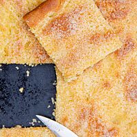 Die goldgelbe Kruste des Zuckerkuchens ist dünn und leicht karamellisiert.