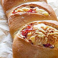 Das goldgelb ausgebackene Handbrot lässt durch seine Einschnitte auf der Oberfläche die Füllung aus Käse und Kochschinken erkennen.