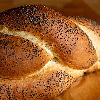 Das schwedische Weißbrot mit aufgesetztem Zopf hat eine goldbraun ausgebackene und mit Mohn bestreute Kruste.