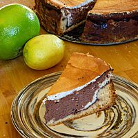 Ein Stück Schoko-Quarktorte zeigt die üppige Schokoladenschicht und den knusprigen Hefeteigboden.
