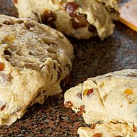 Auf der Oberfläche von drei portionierten Stollenteiglingen sind Sultaninen und Orangeat gut zu erkennen.