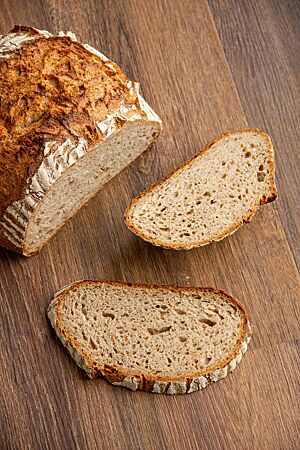 Angeschnitten zeigt das Alles-muss-weg-Brot seine lockere Krume umgeben von der knusprigen Kruste.