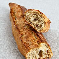 Das kräftig ausgebackene, rustikal aufgerissene Baguette hat eine luftige, grobporige Krume.