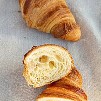 Ein durchgeschnittenes Croissant zeigt die hellgelbe Krume mit mittlerer Porung.