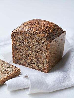 Das Eiweißbrot hat eine glatte, glänzende Kruste und eine dichte Krume, in der jede Menge Saaten und Kerne sichtbar werden.