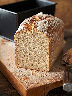 Das in der Kastenform gebackene Eisenbahnerbrot hat eine rustikale, bemehlte Kruste und eine lockere, kleinporige Krume.