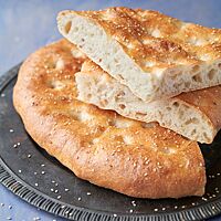 Im Anschnitt zeigt das Döner-Fladenbrot seine wattige, luftige Krume unter der glänzenden, goldgelb ausgebackenen Kruste.