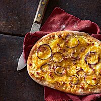 Dinnete klassisch belegt mit Schmand, Speck, Zwiebeln gekochten Kartoffeln.