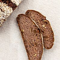 Im Anschnitt des Roggenvollkornbrotes werden die Walnuss- und Feigenstückchen sichtbar.