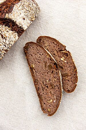 Im Anschnitt des Roggenvollkornbrotes werden die Walnuss- und Feigenstückchen sichtbar.