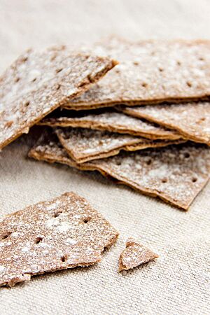 Knusprig und aromatisch liegt das in rechteckige Stücke geschnittene Knäckebrot auf einem Leinentuch.