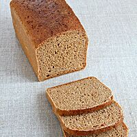 Das in Scheiben geschnittene Einkornvollkornbrot hat eine glatte, glänzende Kruste und eine lockere, elastische Krume.