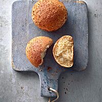 Ein auseinandergebrochenes Leopardenbrötchen zeigt die kleinporige, wattige-weiche Krume umgeben von der dünnen, knuspernden Kruste.