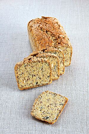Vier Scheiben des Fünfsaatenbrotes zeigen Sonnenblumenkerne, Kürbiskerne, Leinsaat, Quinoa und Hirse in der lockeren Krume.