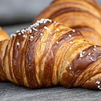 Das mit Salz bestreute Laugencroissant hat eine goldbraun ausgebackene,  zarte Kruste.