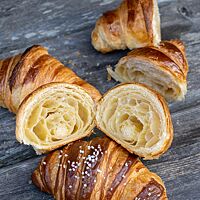 Ein durchgeschnittenes Croissant zeigt seine grobporige, wattige Krume.