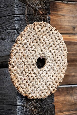 Das durch Trocknen haltbar gemachte Knäckebrot mit Loch in der Mitte hängt an einem Nagel.