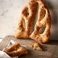 Die Fougasse hat eine goldgelb bis goldbraun ausgebackene Kruste, die mit Rosmarinnadeln und grobem Salz bestreut ist.