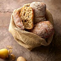 Die eckigen Kartoffelbrötchen haben eine fluffige, mittelporige Krume und eine dünne, zart gemaserte und leicht bemehlte Kruste.