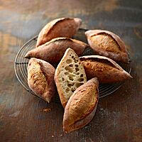 Die ovalen, an den Enden spitz zulaufenden Kipfe mit weit aufgerissenem Einschnitt haben eine lockere Krume mit unregelmäßiger, grober Porung.