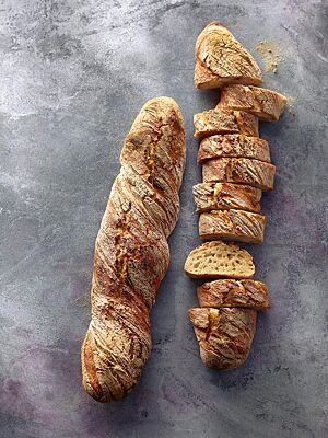 Die langen, stangenförmigen und in sich verdrehten Wurzelbrote haben eine leicht bemehlte, knusprige Kruste und eine helle, mittelporige Krume.