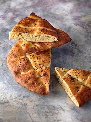 Die klein- bis mittelporige, lockere Krume des Fladenbrotes ist umgeben von einer dünnen, goldbraun ausgebackenen Kruste.