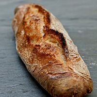 Die rustikal aufgerissene Kruste des Baguettes ist knusprig ausgebacken.