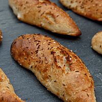 Auf die dünne, goldgelb bis goldbraun ausgebackene Kruste der Dinkelseelen wurde grobes Salz und Kümmel gestreut.