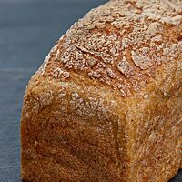 Das glutenfreie Brot wurde in der Kastenform gebacken und hat eine goldbraune, leicht bemehlte Kruste.