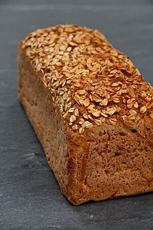 Das in einer Kasternform gebackene Haferbrot hat eine goldbraun ausgebackene, mit Haferflocken bestreute Kruste.