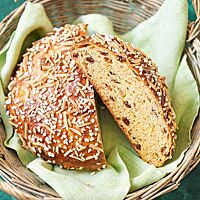 Das Osterbrot hat eine saftige, mit Rosinen gespickte Krume und eine mit Hagelzucker und Mandelstiften bestreute glänzende Kruste.