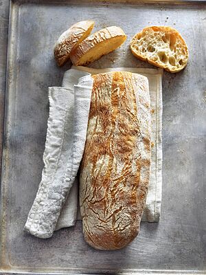 Das goldgelb ausgebackene Ciabatta mit glatter, leicht bemehlter Kruste hat eine mittel- bis grobporige, elastische Krume.