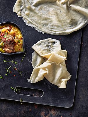 Das Kissra-Fladenbrot ist hellgelb, hauchdünn und weich wie ein Crêpe.