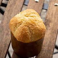 Die in einer Panettone-Form gebackene Sauerteig-Brioche steht auf einem Holzklappstuhl.