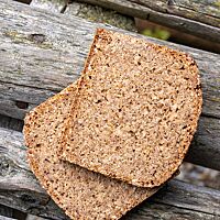 Zwei Scheiben des Schrotmischbrotes lassen das Schrot in der feinporigen, saftigen Krume des Schrotmischbrotes erkennen.
