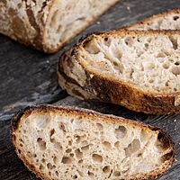 Drei Scheiben des Weizensauerteigbrotes  zeigen die elastische, lockere Krume.