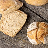 Ein aufgeschnittenes eckiges All-In-Sonntagsbrötchen zeigt die luftige, lockere Krume.