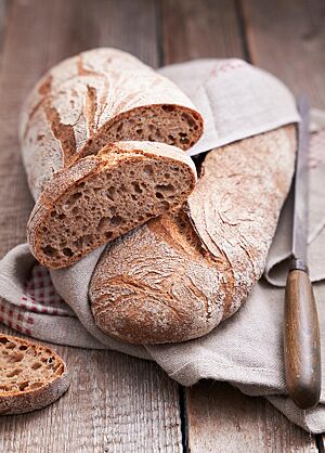 Im Anschnitt zeigt das lange Weizenvollkornbrot die mittelporige, lockere Krume unter der kräftig ausgebackenen, rustikalen Kruste.
