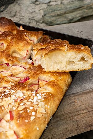 Ein Stück der Süßen Focaccia zeigt die grobporige, wattige Krume.