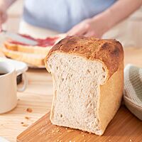 Das im Kasten gebackene Weizenbrot hat eine fluffige, helle Krume und eine goldbraun ausgebackene, glatte Kruste.