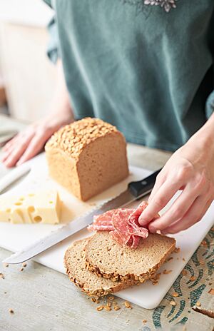 Das im Kasten gebackene glutenfreie Brot hat eine lockere, kleinporige Krume und eine mit Haferflocken bestreute, glatte Kruste.