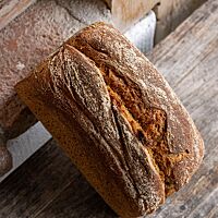 Das im Kasten gebackene Dinkelflockenbrot hat eine kräftig ausgebackene, leicht bemehlte Kruste.