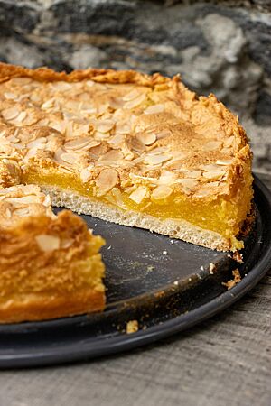 Im Querschnitt der Eierschecke nach Freiberger Art ist der feinporige Hefeteigboden mit der darüberliegenden orange-gelben Füllung zu sehen.